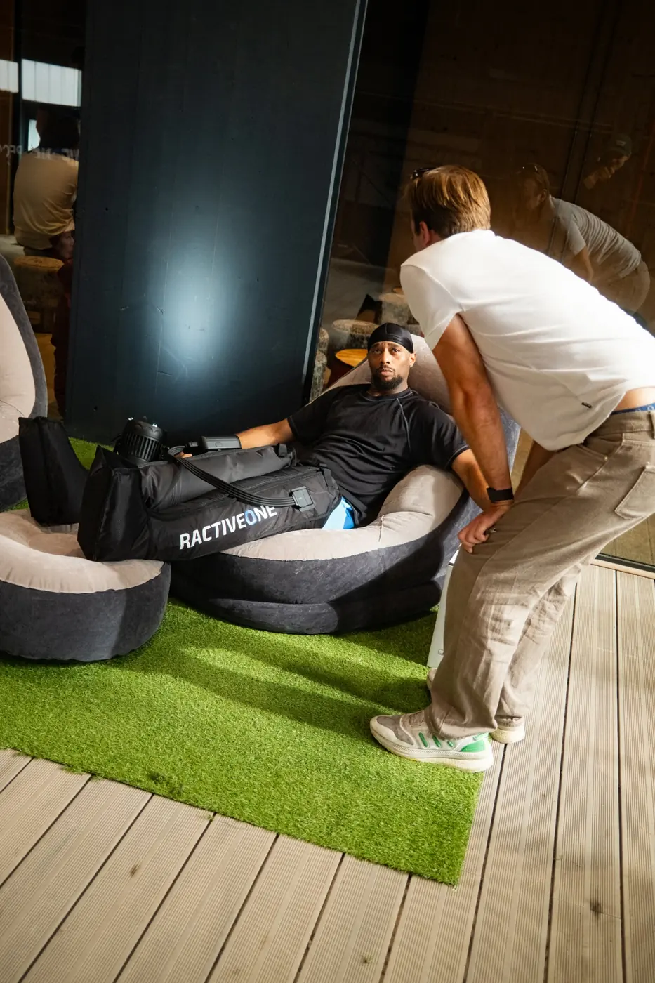 Gast entspannt mit Recovery Boots in der Lounge